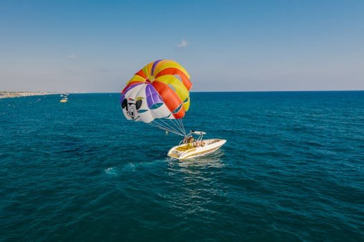 Vibrant parasailing experience over crystal clear ocean water, capturing a thrilling outdoor adventure.