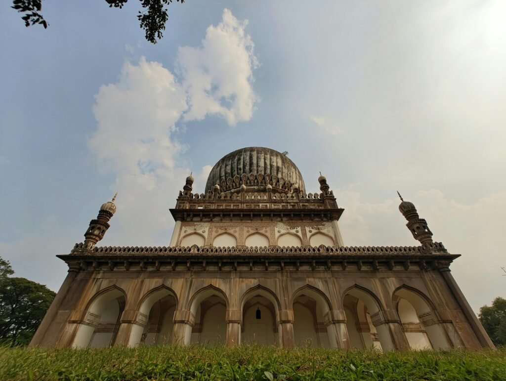 A detailed view of the Qutb Shahi Tomb, showcasing its architectural grandeur against a clear sky in Hyderabad, India.