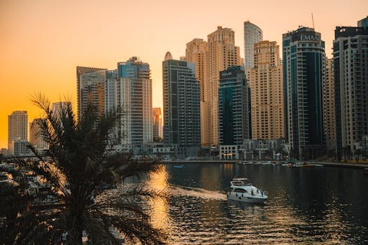 View of Dubai Marina skyscrapers with a boat on the water during a beautiful sunset.